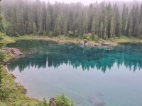 Der Karersee liegt spiegelglatt im Morgennebel